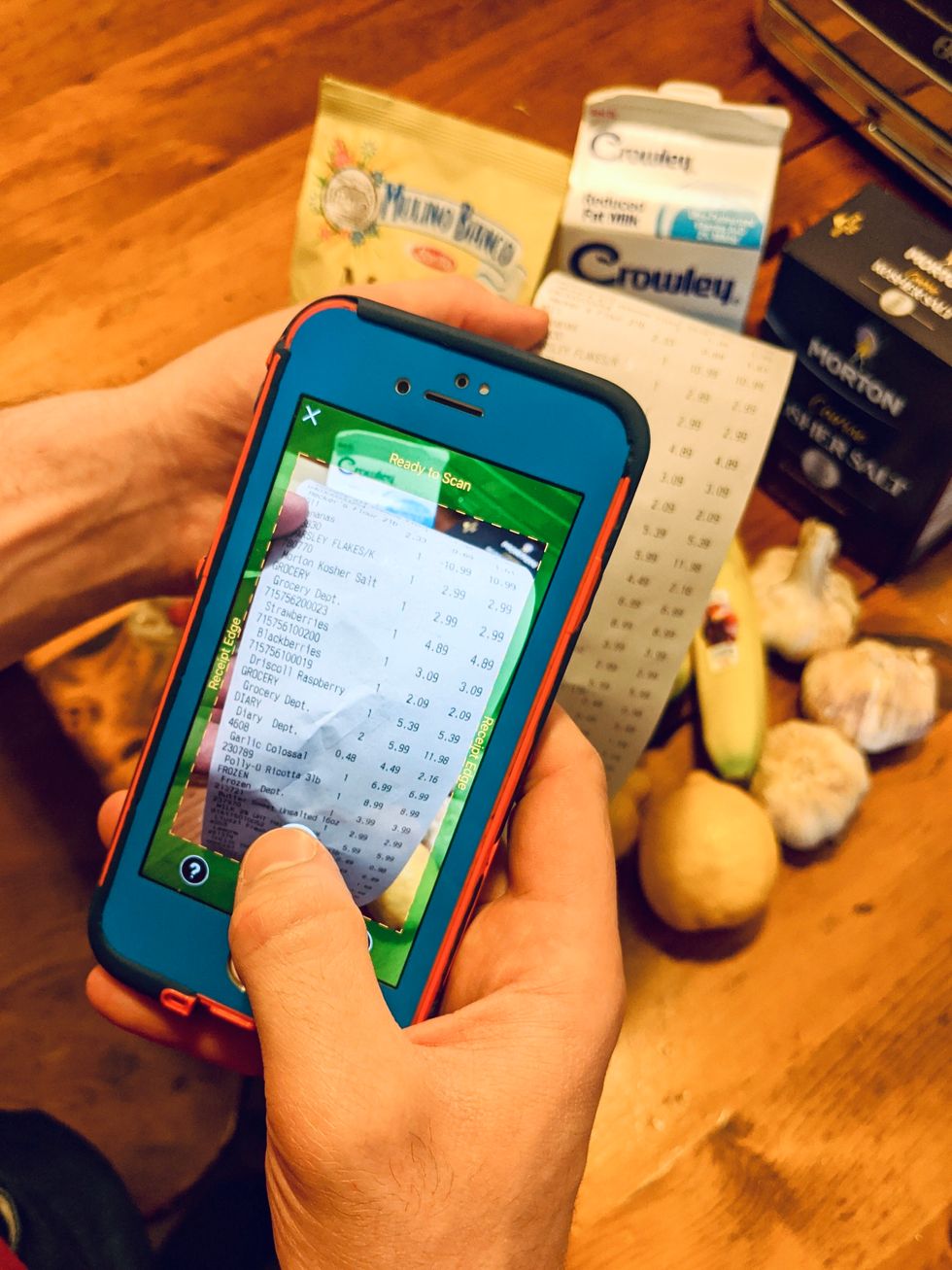 hand holding phone and scanning receipt