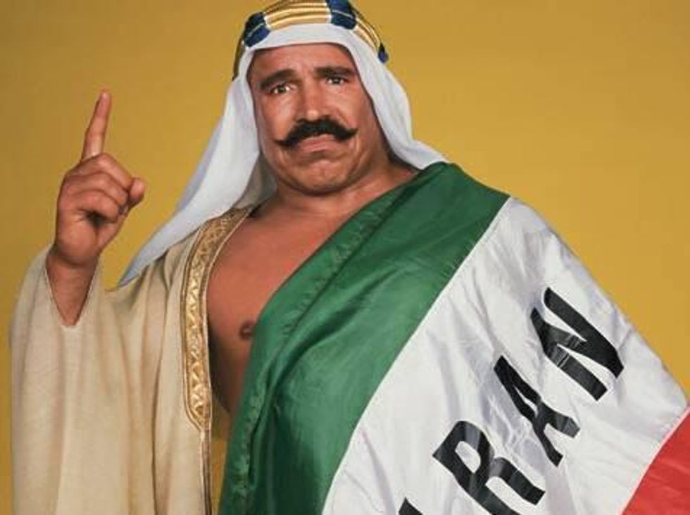 u200bThe Iron Sheik wrapped in an Iranian flag holding up the number one