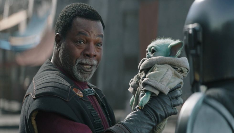 Greef Karga (Carl Weathers) holding Baby Yoda on "The Mandalorian"